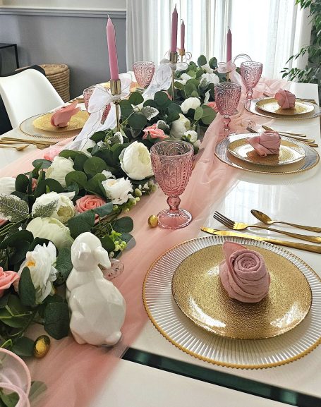Décoration de table rose et doré Table dressée avec fleurs, bougies roses, assiettes dorées et décorations de Pâques.