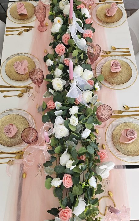 Décoration de table rose et doré Table élégamment dressée avec des fleurs, assiettes et accessoires rose et doré.