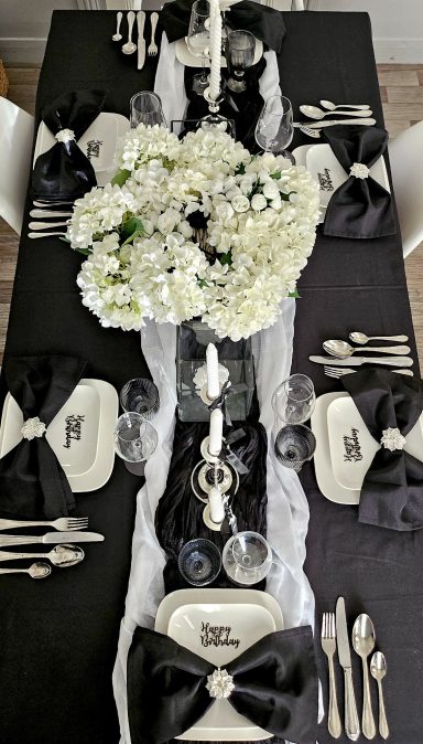 Décoration de table noir et blanc chic – Idée anniversaire élégant Table élégamment dressée avec des fleurs blanches et des serviettes noires.